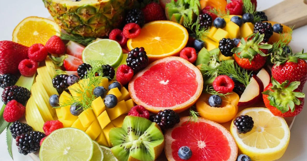 Étal coloré de fruits et légumes riches en vitamine C : poivrons rouges, kiwis, cassis, brocoli et agrumes